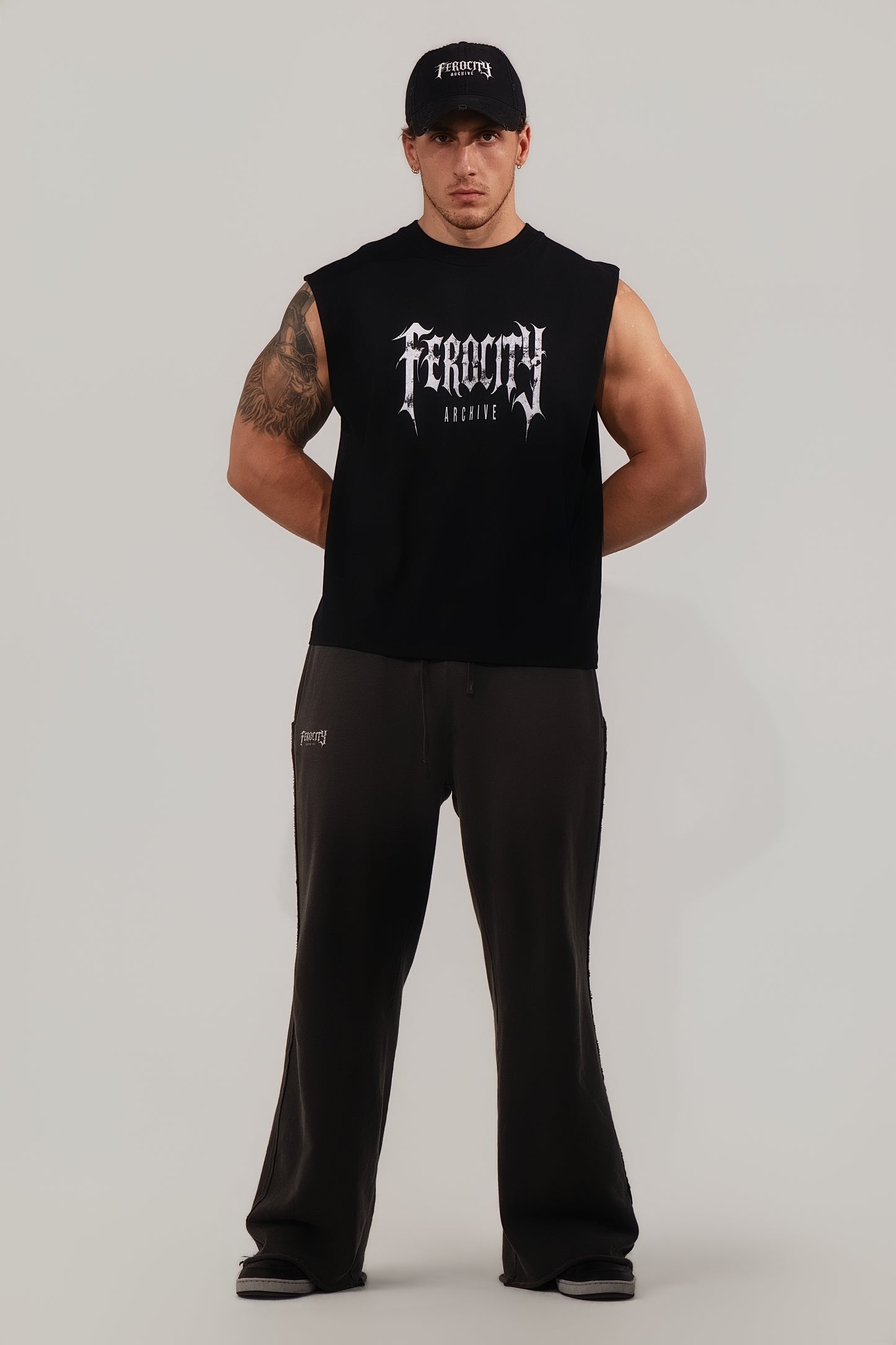Man wearing a black sleeveless shirt with 'Feroce' branding on a gray background