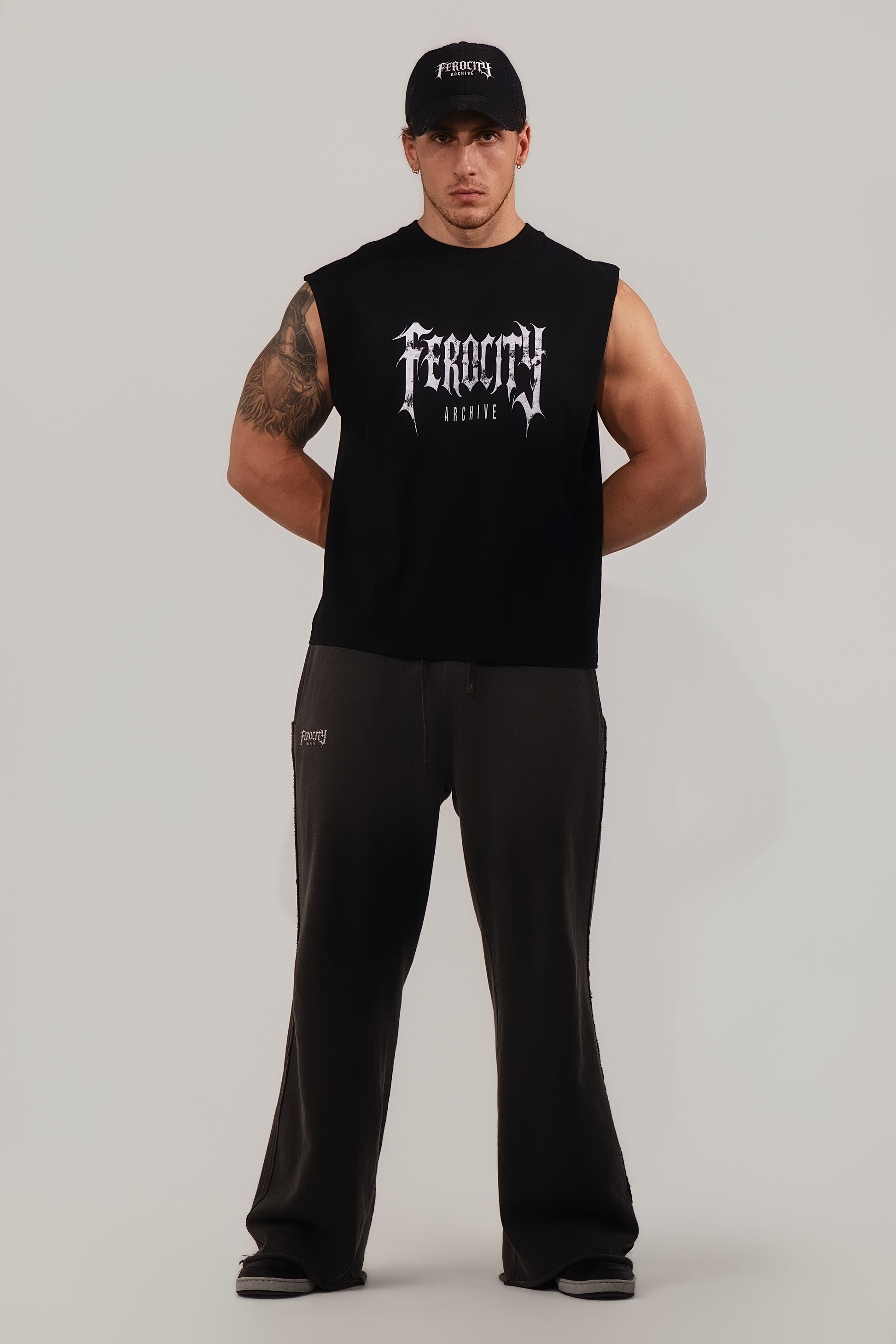 Man wearing a black sleeveless shirt with 'Feroce' branding on a gray background